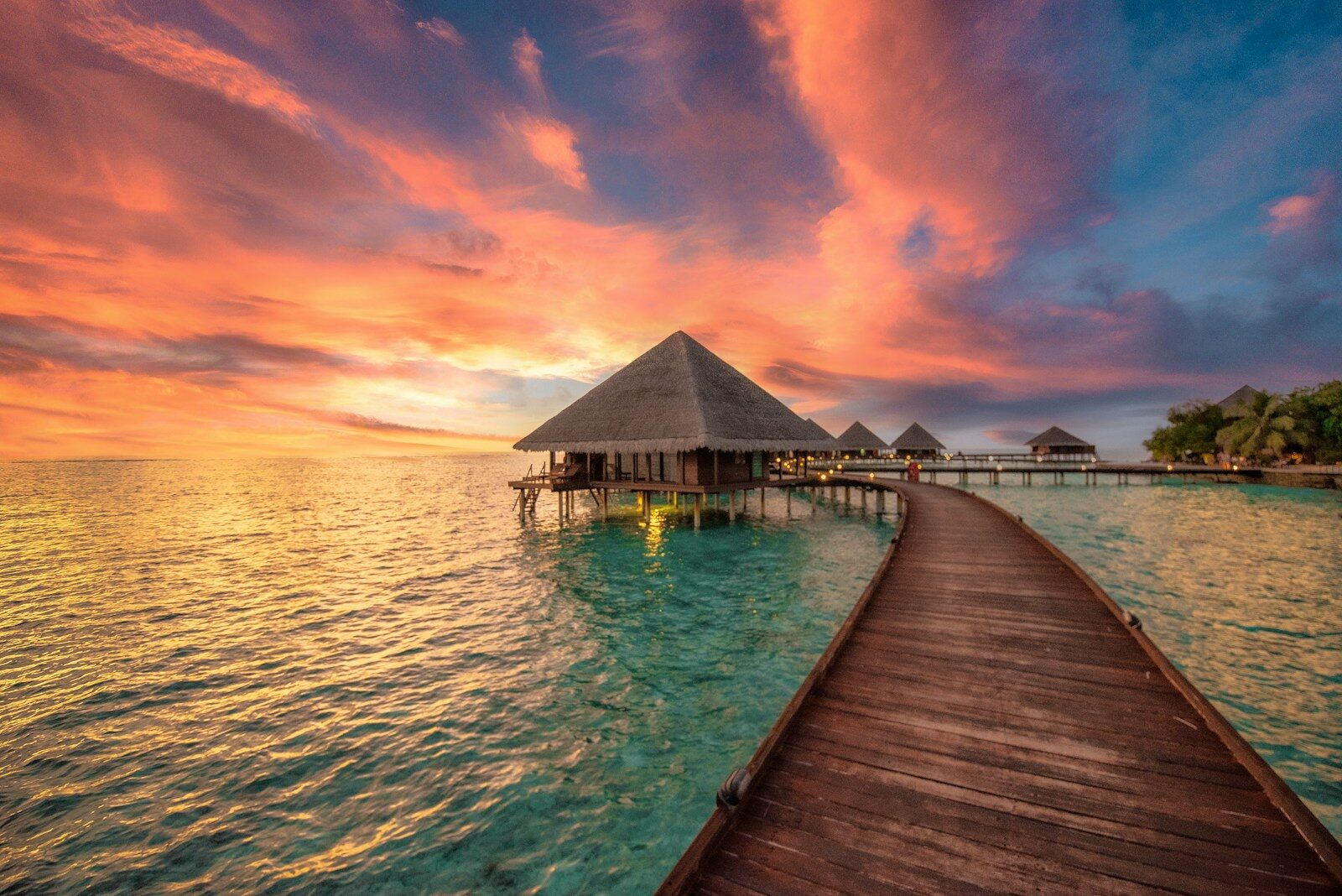 a dock leading to a hut in the ocean