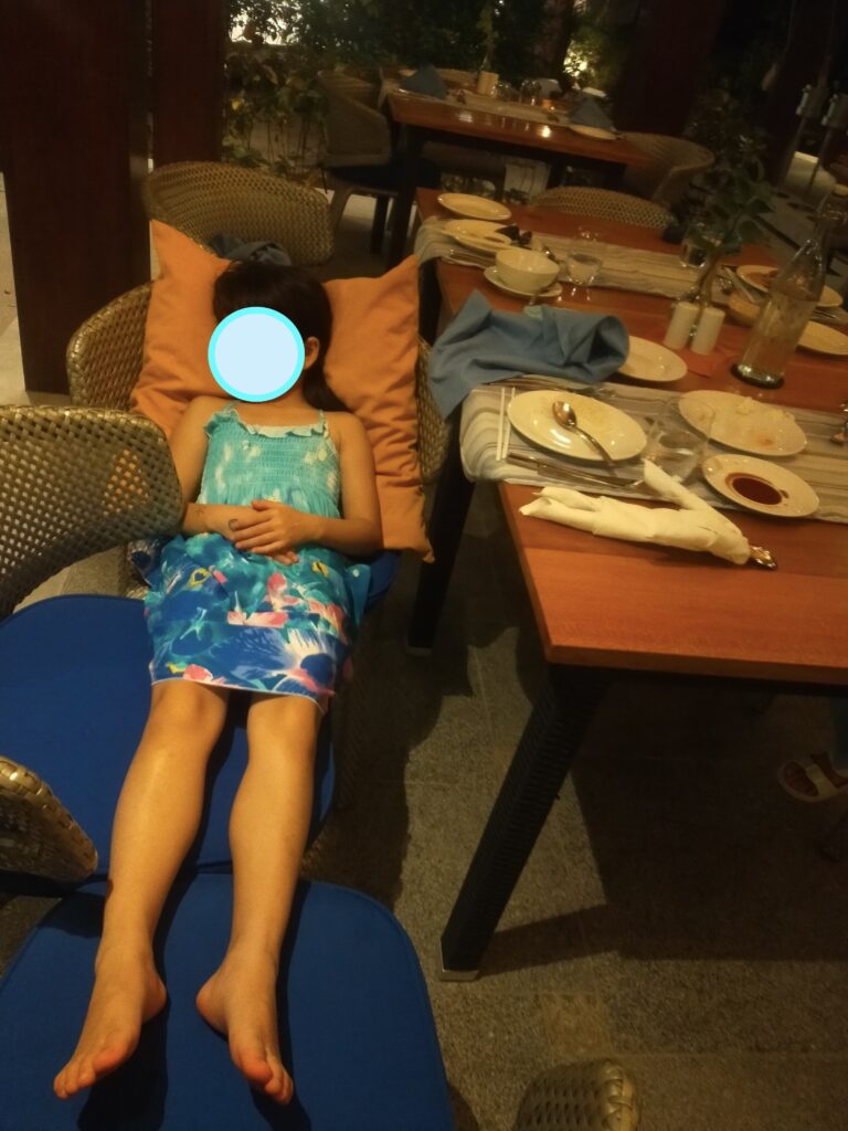 夜のディナー中にレストランの椅子で寝てしまった娘